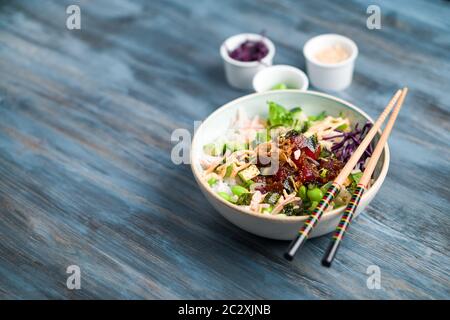 Hawaiianische Thunfisch-Poke-Schale mit Kopierer. Poke ist ein traditionelles hawaiianisches Gericht, das von japanischer und asiatischer Küche beeinflusst wird. AHI Poke wird aus rohem Thunfisch hergestellt Stockfoto