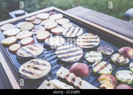 Der Grillabend: Es kann auch vegetarisch sein, mit köstlichem Gurkensalat und gegrilltem Gemüse. Stockfoto