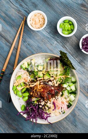 Thunfisch Poke Schüssel vertikale Ansicht von oben. Poke ist ein traditionelles hawaiianisches Gericht, das von japanischer und asiatischer Küche beeinflusst wird. AHI Poke wird aus rohem Thunfisch hergestellt. Stockfoto