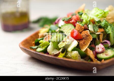Gesunder Salat aus der Nähe. Die Hauptzutat in diesem mittelöstlichen Gericht ist das geröstete Pitabrot, das mit gesundem Gemüse, Kräutern, gemischt wird Stockfoto