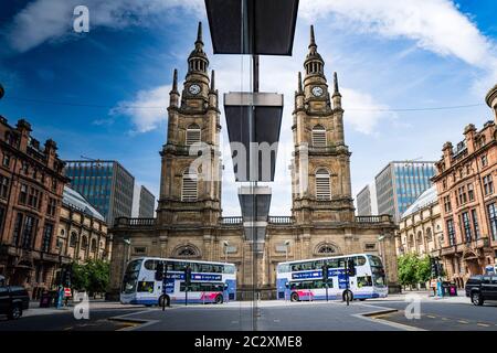 Der erste öffentliche Doppeldecker-Bus des Unternehmens spiegelt sich im Schaufenster im Stadtzentrum von Glasgow, Schottland, Großbritannien, wider Stockfoto