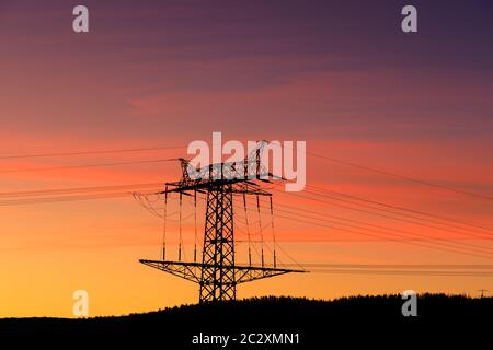 Hochspannungsmast-Freileitung bei Sonnenuntergang Stockfoto