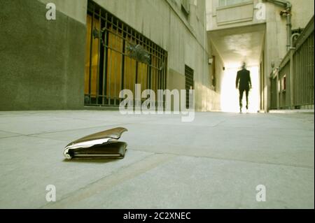 Low Angle View eines Geschäftsmannes zu Fuß, die seine Brieftasche gefallen ist. Stockfoto