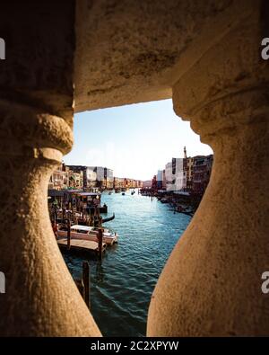 Blick auf eine Gondel durch die Rialtobrücke bei Sonnenuntergang, die älteste der vier Brücken, die den Canal Grande in Venedig überspannen Stockfoto