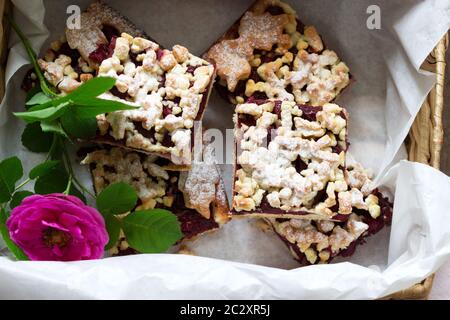 Süßer Kuchen mit Kirschrosenarenen und Streusel auf einem Holzhintergrund. Rustikaler Stil. Stockfoto