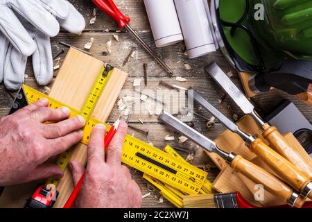 Ansicht von oben. Tischler mit Bleistift, tischlerei Square und metermarkierung die Messung auf einem Holzbrett. Bauwirtschaft, die es selbst tun. Holz- w Stockfoto