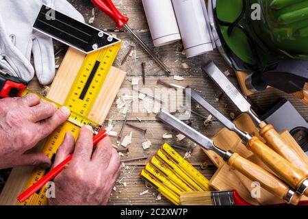 Ansicht von oben. Tischler mit Bleistift, tischlerei Square und metermarkierung die Messung auf einem Holzbrett. Bauwirtschaft, die es selbst tun. Holz- w Stockfoto