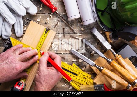 Ansicht von oben. Tischler mit Bleistift, tischlerei Square und metermarkierung die Messung auf einem Holzbrett. Bauwirtschaft, die es selbst tun. Holz- w Stockfoto