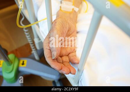 Nahaufnahme der Hand des älteren Patienten, der im Krankenhausbett schläft Stockfoto