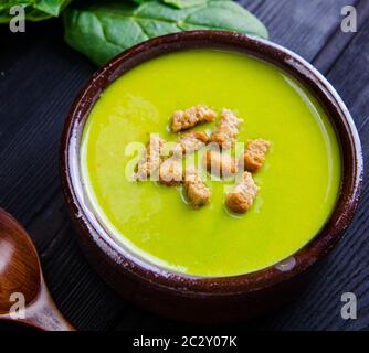 Die Spinatsuppe serviert auf Holzbrett Stockfoto