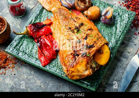 Roter Meerbarsch mit Pilzen und rotem Pfeffer gebacken.Fisch in geröstetem Gemüse Stockfoto