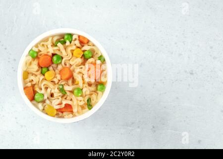 Ramen Schale, instant Soba-nudeln in einem Plastikbecher, mit grünen Erbsen und Karotten, Top Shot mit einem Platz für Text Stockfoto
