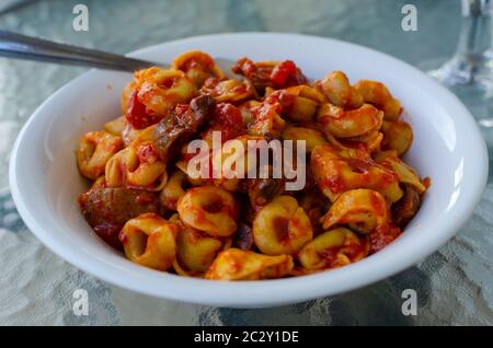 Nahaufnahme einer weißen Schüssel gefüllte Pasta ( Ravioli ) mit einer Tomatensauce und Pilzen Stockfoto