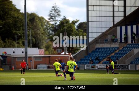 Die Spieler beider Teams und die Beamten machen ein Knie vor dem Sky Bet League zwei Play-off Halbfinale erste Etappe Spiel im JobServe Community Stadium, Colchester. Stockfoto