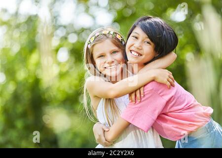 Zwei Mädchen als beste Freunde umarmen in der Natur Stockfoto