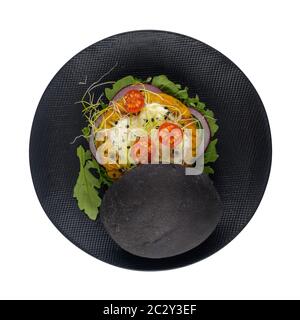 Leckere gegrillte Veggie Burger mit Kichererbsen und Gemüse und schwarzem Brot auf schwarzer Keramikplatte isoliert auf weißem Hintergrund. Stockfoto