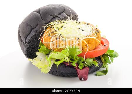 Schmackhafter gegrillter Veggie-Burger mit Kichererbsen und Gemüse auf schwarzem Brot auf weißem Hintergrund. Stockfoto