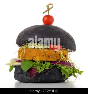 Schmackhafter gegrillter Veggie-Burger mit Kichererbsen und Gemüse auf schwarzem Brot auf weißem Hintergrund. Stockfoto