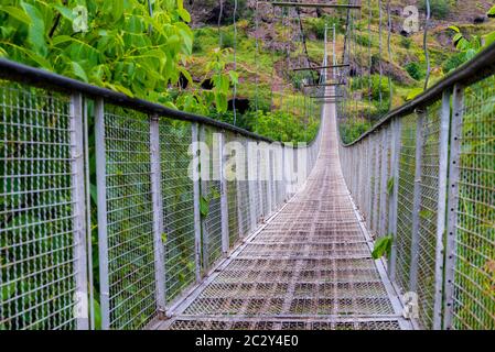 Nahaufnahme einer schwingenden Hängebrücke, die zur Höhlenstadt Khndzoresk über einer Schlucht in den Bergen Armeniens führt Stockfoto