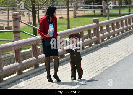 Pjöngjang, Nordkorea - 1. Mai 2019: Die junge Mutter und ihr kleiner Sohn, in der Uniform der koreanischen Volksarmee gekleidet, gehen auf der Pjöngjang-Bude Stockfoto