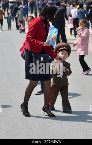 Pjöngjang, Nordkorea - 1. Mai 2019: Die junge Mutter und ihr kleiner Sohn, in der Uniform der koreanischen Volksarmee gekleidet, gehen auf der Pjöngjang-Bude Stockfoto