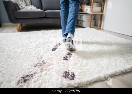 Ansicht von Person zu Fuß mit Schlammigen Stellfläche auf dem Teppich Stockfoto