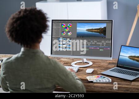 Junge männliche Editor Videobearbeitung am Computer am Arbeitsplatz Stockfoto