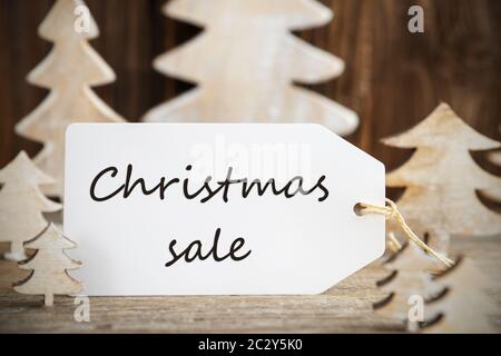 Etikett mit englischem Text Weihnachten Verkauf. Weiß Holz- Weihnachten Baum als Dekoration. Braun Holz- Hintergrund Stockfoto