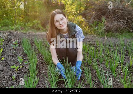 Frau arbeitet auf dem Boden und wächst Bio-Pflanzen, Obst und Gemüse Stockfoto