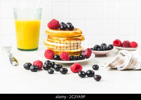 Süße hausgemachte Pfannkuchen mit Blaubeeren und Himbeeren Stockfoto