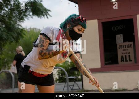 Austin, TX USA 18. Juni 2020: Die Straßenkünstlerin Vanessa Mora hilft, ein Wandbild vor dem legendären Victory Grill in der East 11th Street zu malen, das zwei Tage lang "Black Artists Matters" sagt, nachdem die Gruppe "Black Austin Matters" in großen gelben Buchstaben auf der Congress Avenue, der Hauptstraße von Austin, TX, gemalt hatte. Mehrere andere US-Städte haben Wandbilder geschaffen, beginnend mit der "Black Lives Matter" in der Nähe des Weißen Hauses in Washington, DC.Quelle: Bob Daemmrich/Alamy Live News Stockfoto