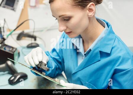 Optische Qualitätskontrolle und Montageprüfung eines elektronischen Produkts im Werk Stockfoto