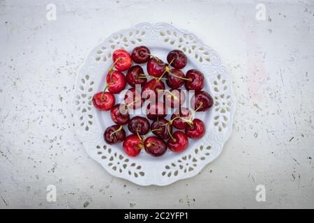 Rote Kirschen in einer Schüssel, auf einem stilvollen weißen Tisch Stockfoto