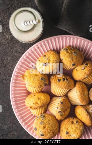 Schmackhafte Schokoladenmuffins. Süße Cupcakes auf pinkfarbenem Teller. Draufsicht. Stockfoto