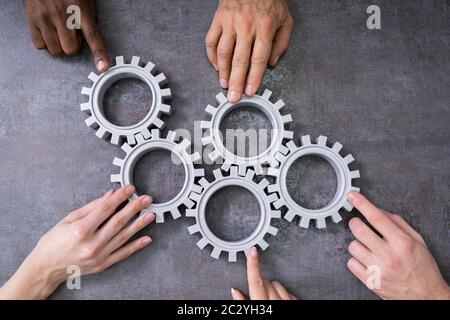 Gruppe von Geschäftsleuten zusammen Gänge verbinden auf Tabelle am Arbeitsplatz Stockfoto