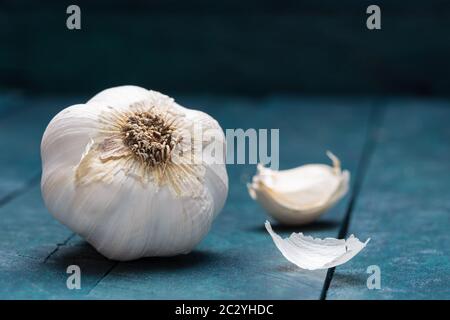 Weißer Knoblauch auf petrolfarbenem Holzhintergrund. Stockfoto