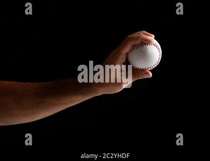 Baseball Pitcher, Nahaufnahme der Hand auf schwarzem Hintergrund zu werfen. Stockfoto