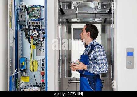Techniker Reparieren Bedienfeld Des Defekten Elevators Stockfoto