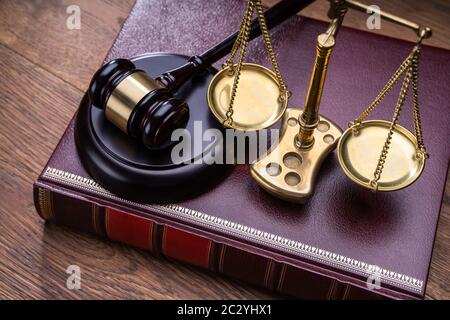 Holz- Hammer mit goldenen Skala in der Nähe von Buch am Tisch Stockfoto