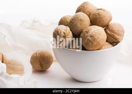 Walnüsse in einer weißen Keramikschale auf weißem Hintergrund Stockfoto