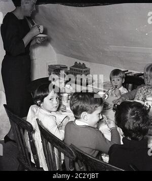 1960er, historische, kleine Kinder bei einer Geburtstagsfeier sitzen an einem Tisch, Essen, England, Großbritannien. Stockfoto