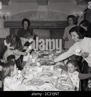 1960er, historisch, Mütter, die den Esstisch bei einer Kindergeburtstag, England, Großbritannien überwachen. Stockfoto