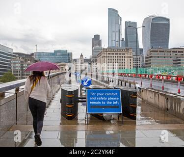 London, Großbritannien - 17. Juni 2020: Walking Lanes auf der London Bridge, um sicherzustellen, dass die Menschen die sozialen Distanzierungsmaßnahmen während des Coronavirus pa folgen Stockfoto