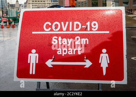 London, Großbritannien - 17. Juni 2020: Ein Schild im Zentrum von London, das die Menschen daran erinnert, den sozialen Distanzierungsrichtlinien zu folgen und 2 Meter von anderen entfernt zu bleiben. Stockfoto