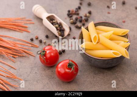 Mischung aus Pasta aus Weizengrieß, Quinoa und Azuki-Bohnen auf braunem Strukturhintergrund Stockfoto