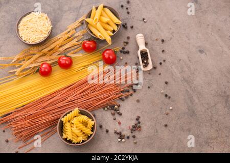 Mischung aus Pasta aus Weizengrieß, Quinoa und Azuki-Bohnen auf braunem Strukturhintergrund Stockfoto