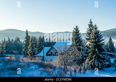 Häuser mit Schnee bedeckt in einer fantastischen Winterlandschaft von Ortoaia, Dorna Arini, Suceava County, Rumänien Stockfoto