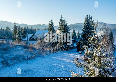 Häuser mit Schnee bedeckt in einer fantastischen Winterlandschaft von Ortoaia, Dorna Arini, Suceava County, Rumänien Stockfoto