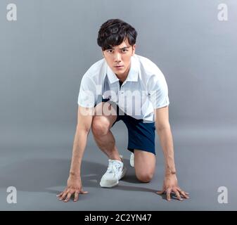 Junger Mann in Startposition Stockfoto