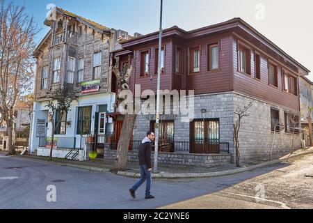 Istanbul, Türkei - 13. Februar 2020: Buyukada Island, eine der Prinzeninseln in Adalar Region, ein Passant geht an zwei zweistöckigen Häusern, eines von Stockfoto